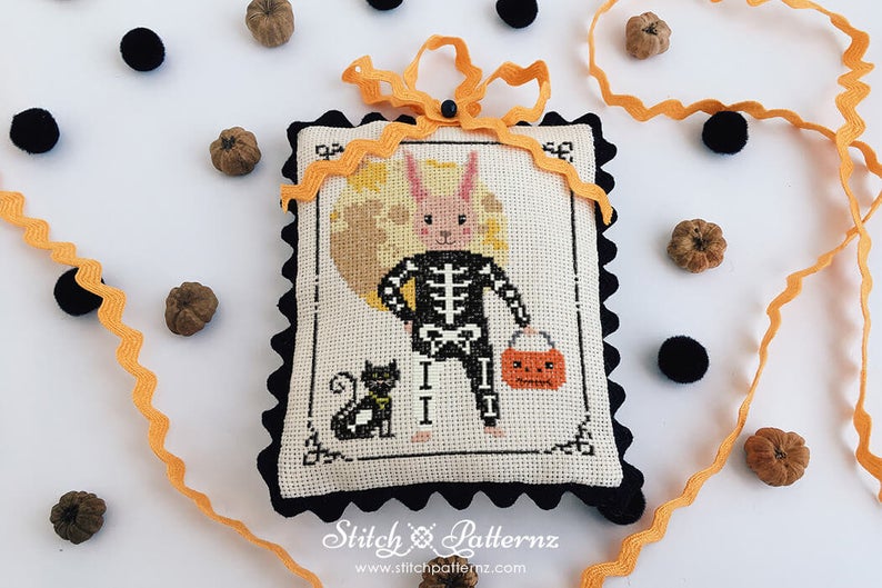 pictured: bunny rabbit in skeleton costume done in cross stitch