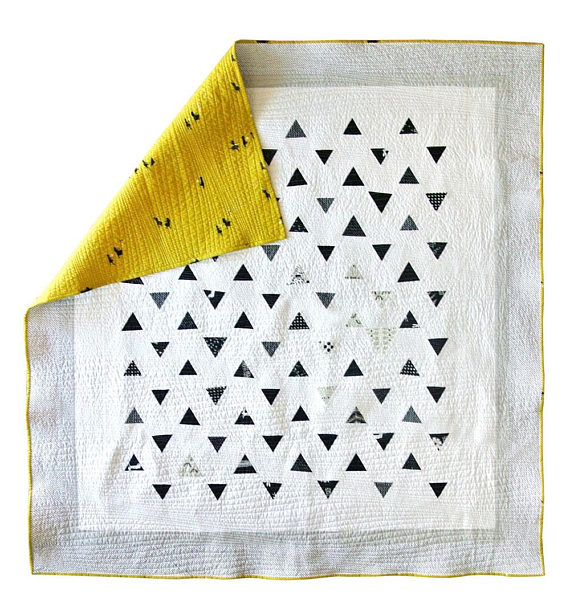 pictured white quilt with black triangles and a yellow back corner folded over
