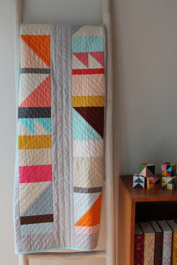 pictured modern quilt hanging on a quilt ladder