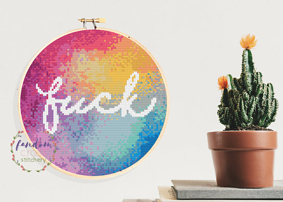 pictured rainbow cross stitches covering an entire hoop with word fuck in white