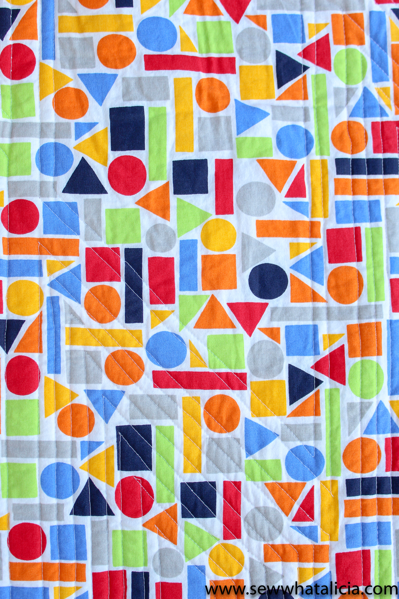 Scrappy Easy Rainbow Quilt Pattern and Tutorial: Pictured back of quilt with straight line quilting evident. | www.sewwhatalicia.com