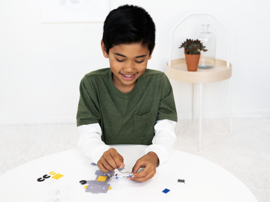 pictured young boy sewing robot circuit