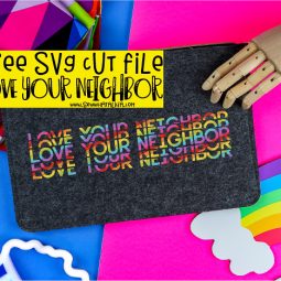 pictured zipper pouch with love your neighbor cut file with wooden hand, rainbow sign, and colorful fabric